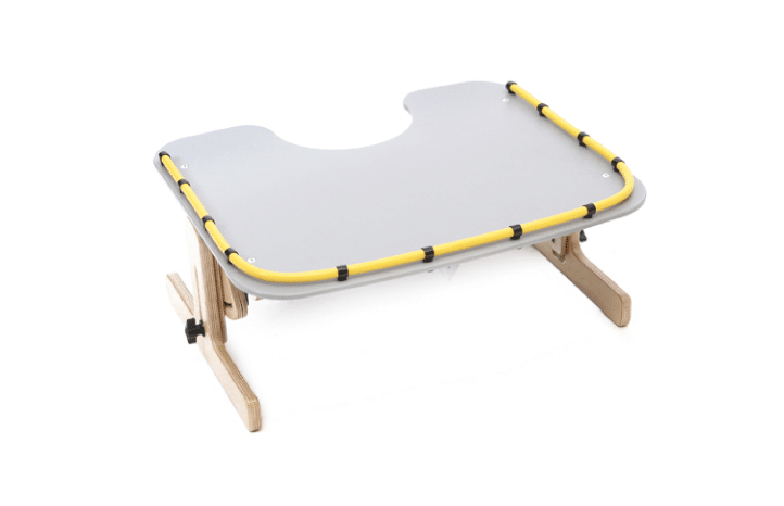 Therapy Tray da Jenx, em dois tamanhos. Uma mesa de atividades ajustável em ângulo e em altura, com recorte no centro para um melhor alcance da criança à mesa.
